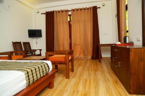 坦加拉Heaven in Satinwoods的一间卧室配有一张床、一张书桌和一台电视