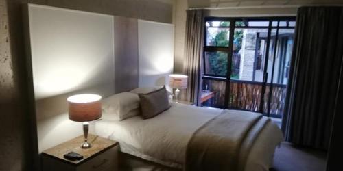 鲁德普特Gold Crest Guesthouse的一间卧室设有一张大床和一个窗户。