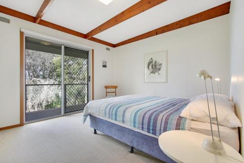 梅顿苍鹭升起度假屋的一间卧室设有一张床和一个大窗户