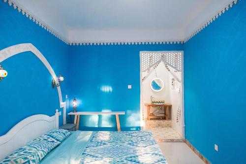 吐鲁番达卜青年旅舍（吐鲁番葡萄小镇店）的蓝色的卧室,配有床和蓝色的墙壁