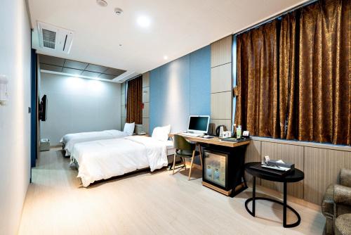 始兴市Siheung Seoul Tourist Hotel的酒店客房配有一张床和一张带电脑的书桌