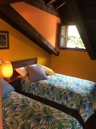 EspinaredoCasa rural Espinareu的一间卧室设有两张床和窗户。