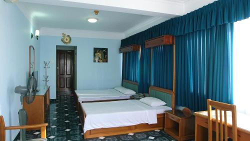 头顿Hoa Tieu Guesthouse的蓝色墙壁客房的两张床