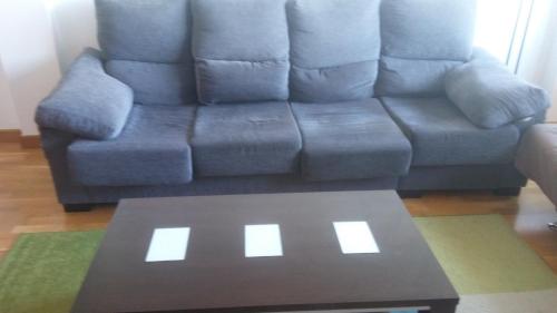卢戈Precioso apartamento的客厅配有蓝色沙发及茶几