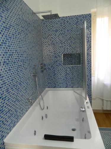 巴勒莫LE STANZE DI LUCA的浴室铺有蓝色瓷砖,配有白色浴缸。