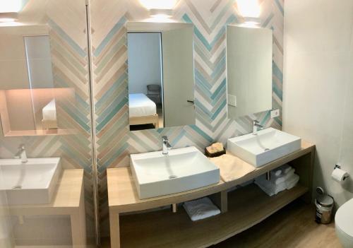 卡托利卡Hotel President的浴室设有2个水槽和镜子
