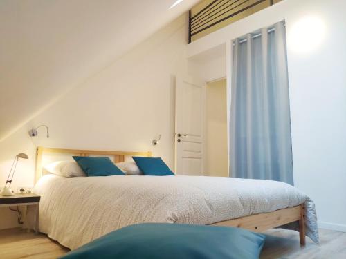诺让莱罗特鲁Maison de ville centre Nogent le Rotrou的一间卧室配有一张带蓝色枕头的大床