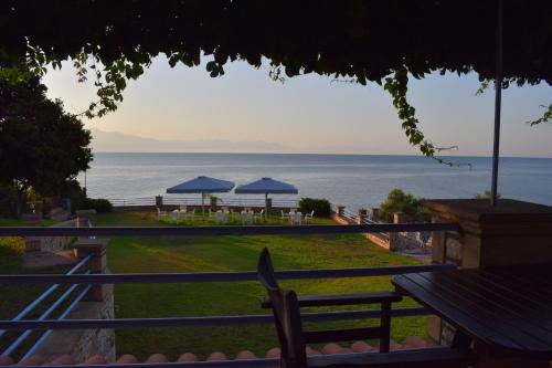 Kalamaki MessiniaAlexandros Apartments & Αλέξανδρος Villas的配有桌子和遮阳伞的度假村享有海洋美景