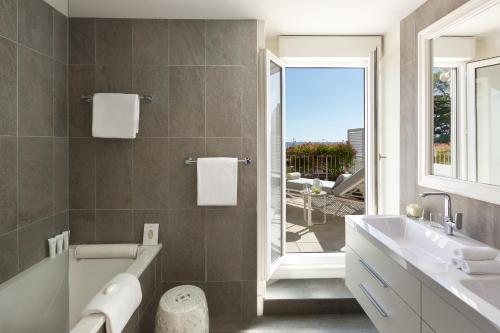 拉波勒拉波勒皇家吕西安巴里亚酒店的带浴缸、水槽和窗户的浴室