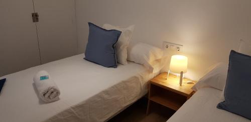 塞戈尔韦Alojamientos Segóbriga Rural (Tahona)的一间卧室配有两张带蓝色枕头和灯的床。