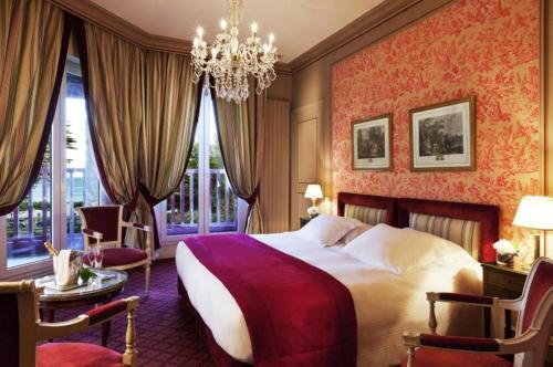 拉波勒乐卡斯特玛丽露易丝酒店的一间卧室配有一张大床和一个吊灯。