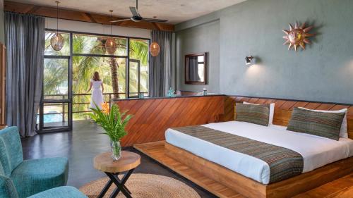 坦加拉兰卡瓦特拉海洋度假酒店及Spa的一间卧室配有一张床,另一位女士望向窗外
