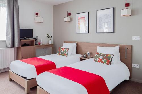 奥尔良Appart'City Confort Orléans的一间卧室配有两张红色和白色床单