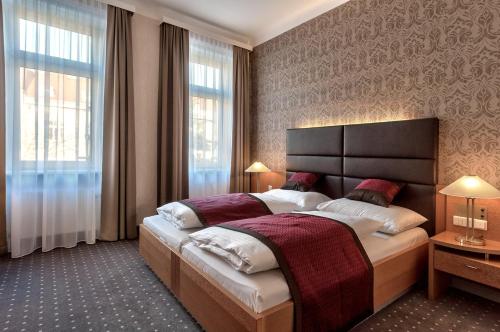 维也纳科尔蒂纳丹俱乐部酒店的一间卧室设有一张大床和一个大窗户