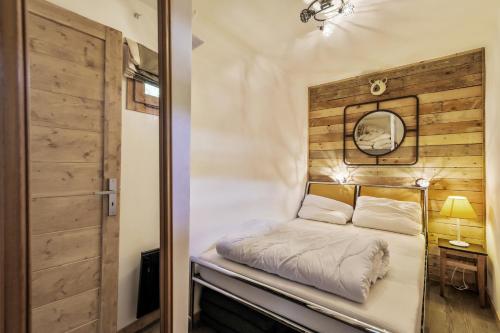 美贝尔Residence Les Ravines - maeva Home的木墙客房内的小床