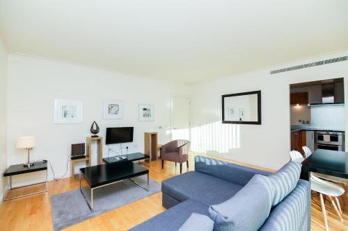 伦敦地平线金丝雀码头公寓的一间带蓝色沙发的客厅和一间厨房