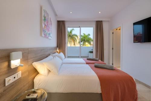 马斯帕洛马斯Villa Deluxe Suites Maspalomas的酒店客房设有两张床和电视。