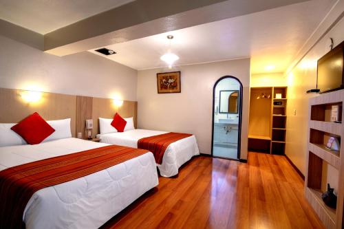库斯科Royal Inka II的酒店客房设有两张床和窗户。
