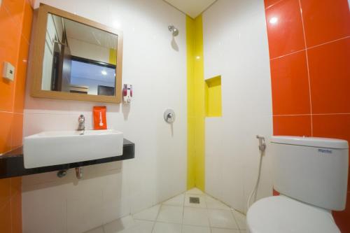 安汶Budget Hotel Ambon的一间带卫生间、水槽和镜子的浴室