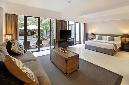 勒吉安Hotel NEO+ Kuta Legian by ASTON的一间卧室设有一张床和一间客厅。
