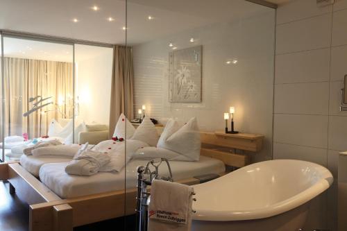 萨斯阿尔马格尔皮尔明楚尔布里根健康水疗酒店的一间带四张床和浴缸的浴室