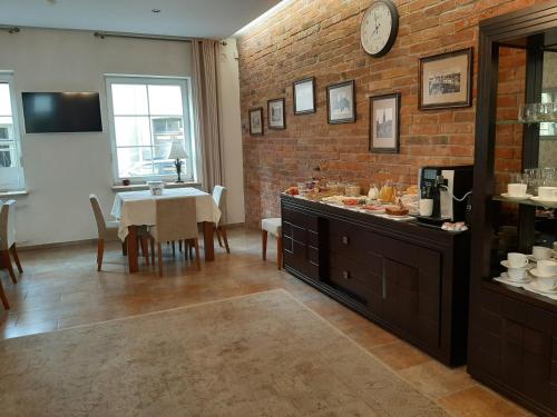 克莱佩达普雷里乌迪亚酒店的一间设有桌子和砖墙的用餐室
