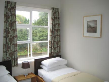 威姆斯洛The Kings Arms的一间卧室设有两张床和窗户。
