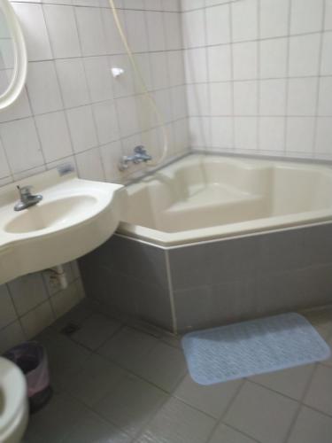 Wenquan知本喻禾溫泉民宿的浴室设有盥洗盆和卫生间旁的浴缸。