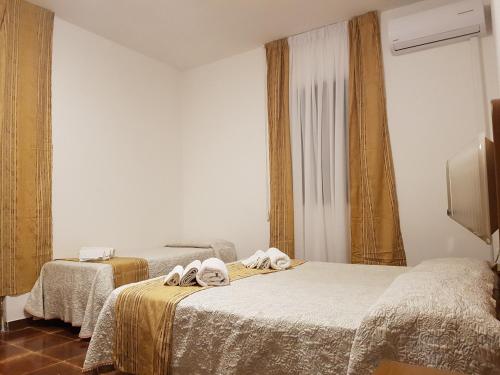 莱波拉诺Villa Giada-8 appartamenti的一间卧室配有两张带毛巾的床