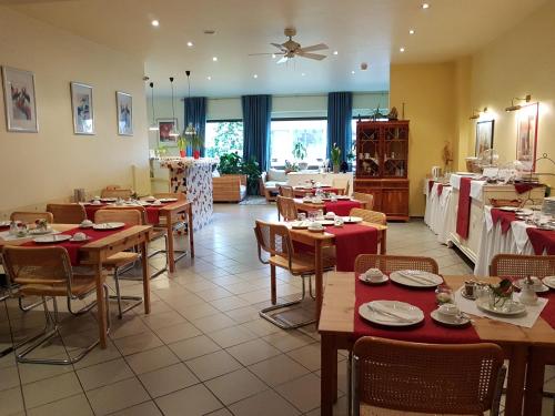 科隆科隆艺术酒店的餐厅设有木桌、椅子和红色桌布