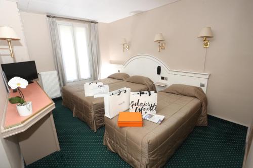 巴黎阿尔纳酒店的酒店客房设有两张床和一张桌子。