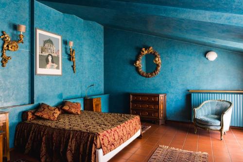 皮耶韦迪索利戈利诺宾馆的卧室拥有蓝色的墙壁,配有一张床和椅子