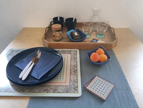 YssingeauxChatimbarbe的一张桌子,上面有蓝色的盘子和橙子碗