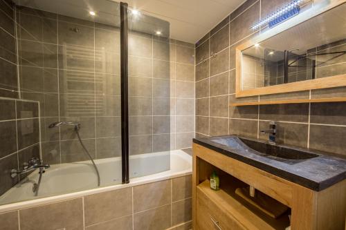 阿克1800Grand Arbois, les Arcs 1800的浴室配有盥洗盆和浴缸。