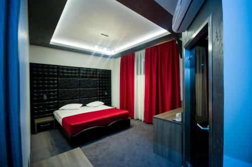 塔古玖Hotel Aqua的一间带红色床的卧室和一间浴室