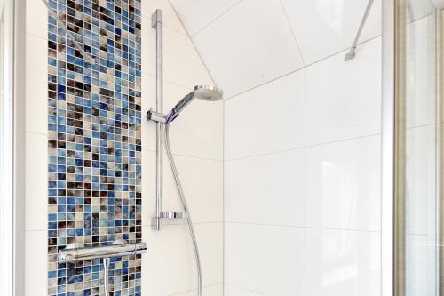 滕宁Solskin的浴室设有蓝色瓷砖淋浴。