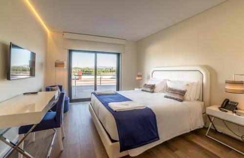科维良Terrace Serra Hotel的一间卧室配有一张床、一张书桌和一个窗户。
