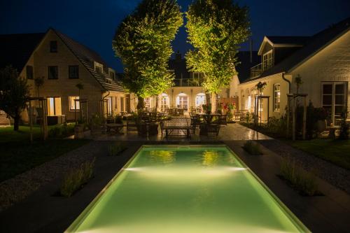 摩尔苏姆霍夫画廊酒店的夜间在房子的院子中的一个游泳池