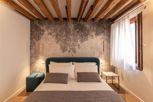 威尼斯La Finestra sulle Beccarie的一间卧室设有一张大床和墙壁
