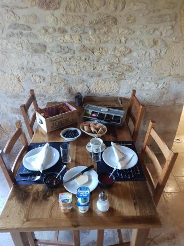 AubasL'étable gourmande chambres d'hôtes et ferme auberge的一张木桌,上面放着食物盘