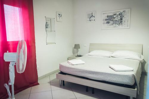 比萨Pisacentro Guest House的一间卧室配有床和红色窗帘