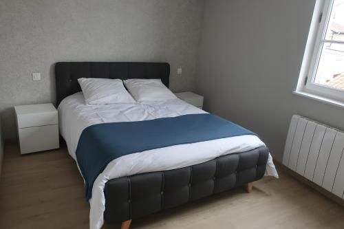 索恩河畔贝尔维尔Aux Portes du Beaujolais的卧室内的一张带蓝色和白色棉被的床