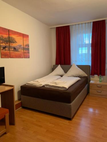特罗辛根Linde Restaurant & Hotel的一间设有床铺的卧室,位于一间设有红色窗帘的房间