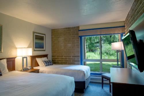 范尔Sandstone Creek Club Condominiums的酒店客房设有两张床和窗户。