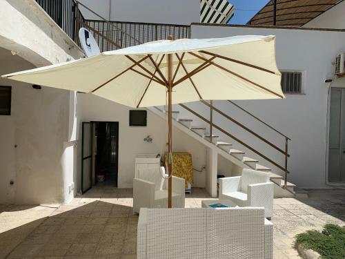 圣凯撒利亚温泉Villa Azzurra Sct的一把大白伞,坐在椅子和楼梯旁