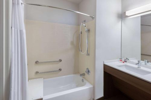 大学城Microtel Inn & Suites by Wyndham College Station的带浴缸、水槽和淋浴的浴室