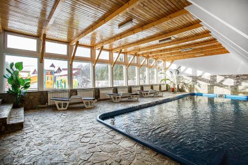 普雷代亚尔普雷代亚尔玛丽亚乡村别墅的大型客房的游泳池,设有大窗户