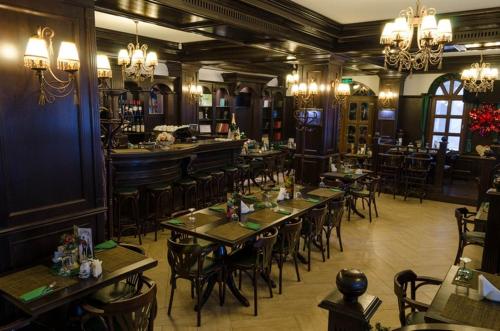 布什泰尼科纳克巴伐利亚酒店的一间带桌椅的餐厅和一间酒吧