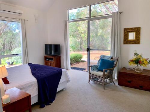 玛格丽特河原野之家住宿加早餐旅馆的卧室配有床、椅子和窗户。