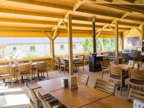 Nieuwland格伦蒂尔野营酒店的一间带木桌和椅子的餐厅以及庭院